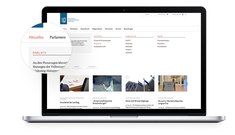 Webseite aktuelles des Landtages Schleswig-Holstein auf Laptop mit Lupenvergrößerung der Navigation