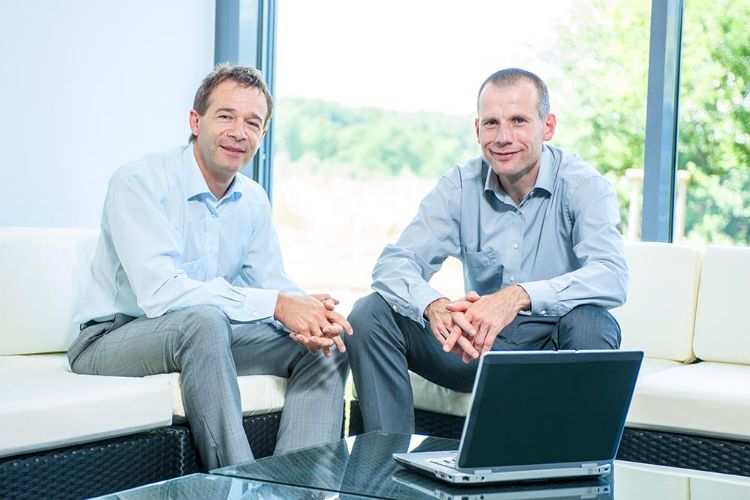Geschäftsleitung: Andreas Scher & Birger Bösel Andreas Scher und Birger Bösel sitzen auf ein Rattanmöbeln im Foyer von PLANET IC
