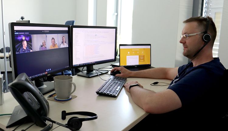 Wemag-Team Onlinemeeting PLANET IC Wemag-Team im Onlinemeeting. Ein Mitarbeiter vor dem Bildschirm. Die anderen sind online dazugeschalten.