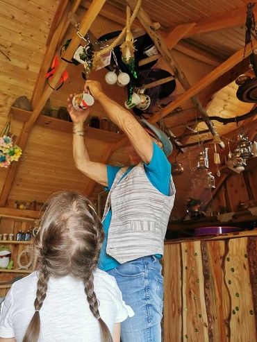 Wolfgang Woitag kettet eine Tasse an der Decke des Hexenhauses an