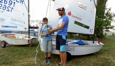 Segelboot wird mit sprudelndem Sekt getauft