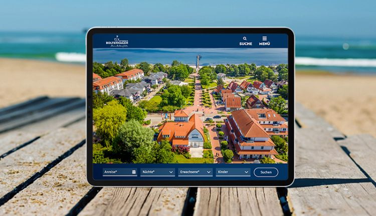 Tablet mit der Startseite von boltenhagen.de, dass am Strand auf einen Holzsteg steht
