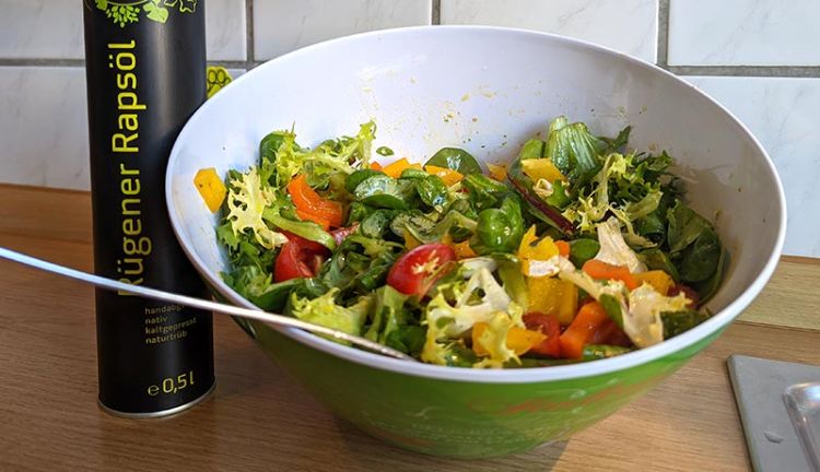 Salat mit Ruegener Rapsöl bunter Salat mit einer Flasche Ruegener Rapsöl daneben