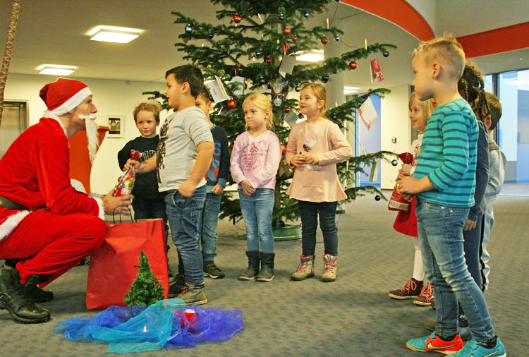 Bescherung mit dem Weihnachtsmann unter dem Tannenbaum